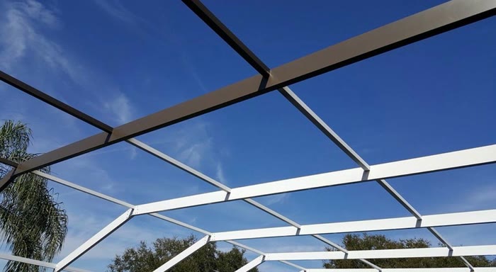 Freshly painted white cage beams crossing against a deep blue sky.
